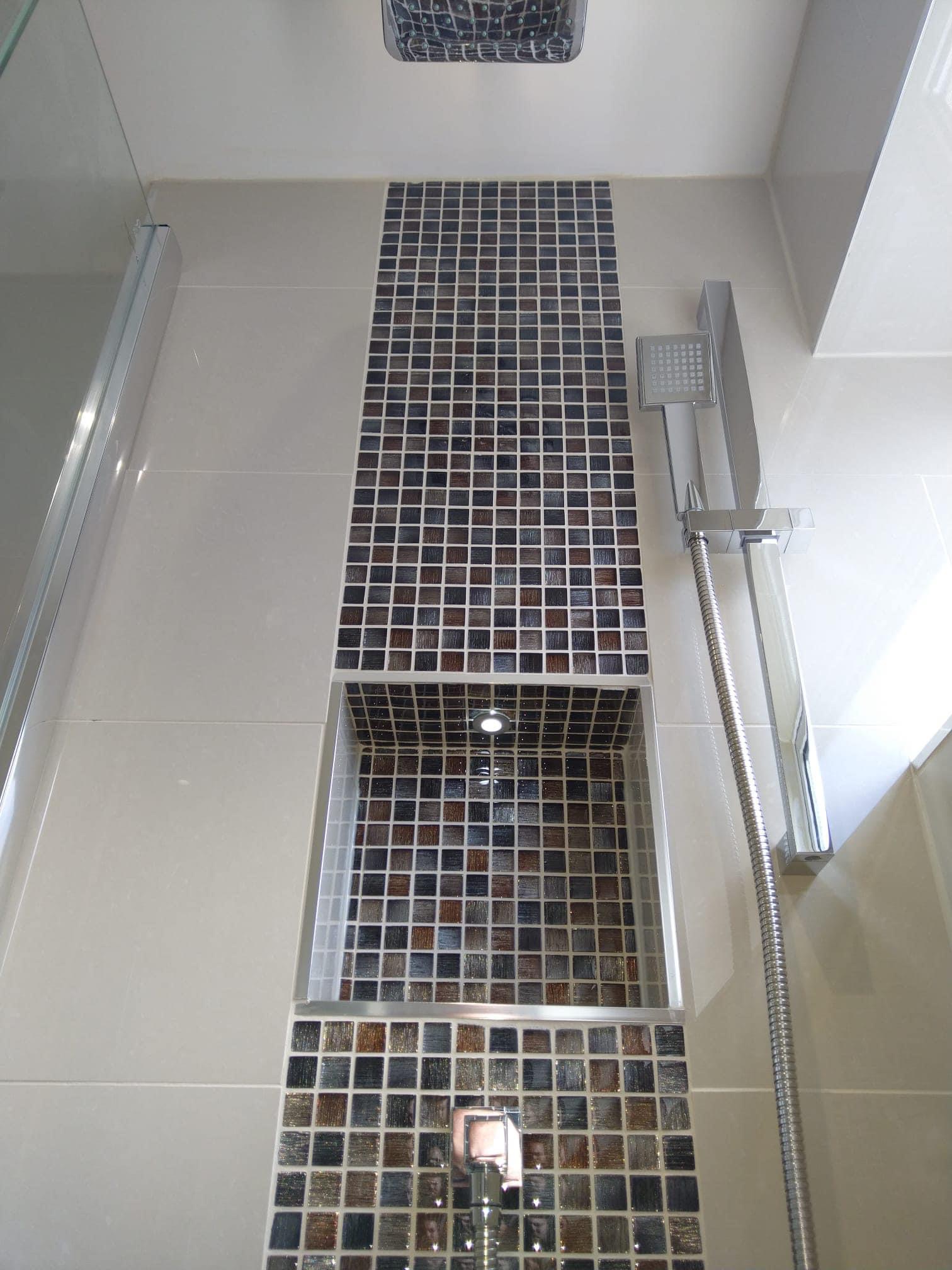 Walk-in shower with a mosaic tile strip and recessed niche, fitted by Crystal Water